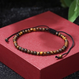 Close-up of natural tiger eye beaded bracelet with adjustable black braided nylon cord