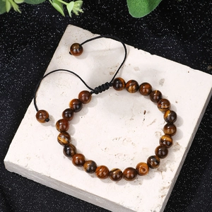 Macro shot of polished tiger eye stone beads with an adjustable black braided cord detail