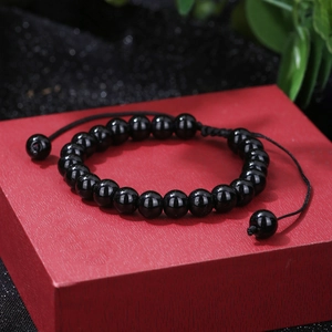 Detailed close-up of 8mm black lava stone beaded bracelet with adjustable woven rope