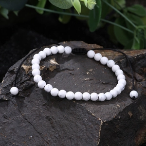 Macro view of 8mm white howlite beaded bracelet with adjustable black braided cord