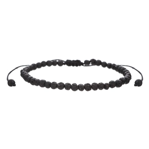 Macro detail of natural porous black lava stone beads and adjustable braided cord knot