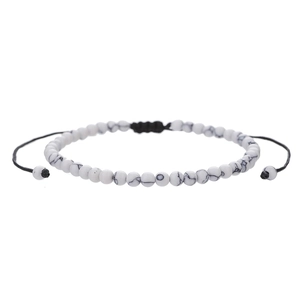 Close-up of white turquoise beaded bracelet with adjustable black braided cord and stone texture