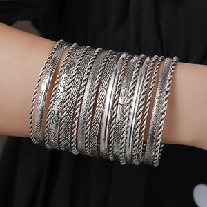 Close-up of bohemian style silver hammered bangles set with intricate textured patterns