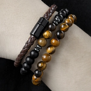 Detail of beaded men's bracelets with tiger eye stone and braided leather magnetic clasp