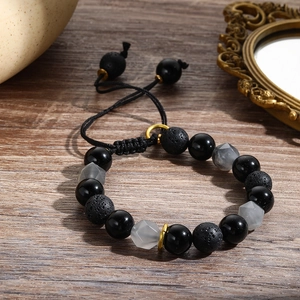 Detailansicht eines 10mm Lavastein- und Obsidian-Perlenarmbands auf dunklem Holz