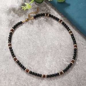 Detalle macro de collar bohemio con piedra de lava, ojo de tigre y cierre de mosquetón ajustable