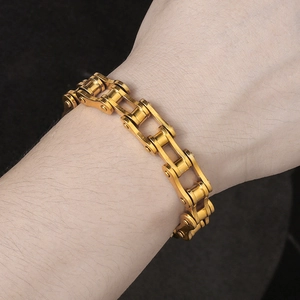 Primo piano di un bracciale da uomo a catena di bicicletta dorata in acciaio inossidabile