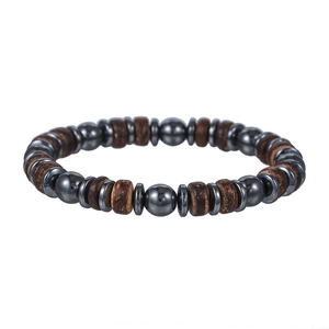 Detail van kralenarmband met hematiet, houten kralen en zilveren tussenringen op wit decor