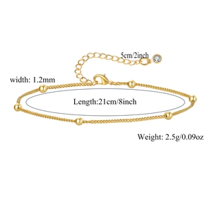 Detail view of gold bead anklet with lobster clasp, extender chain and zircon charm