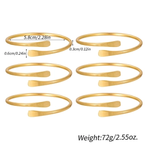 Detailed view of 6 gold hollow bangles with brushed metal texture and open cuff design