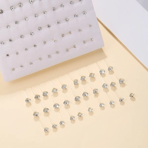 Gedetailleerde weergave van 50 paar strass-oorknopjes op een displaybord