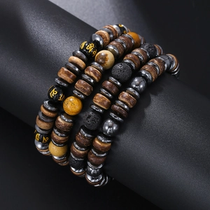 Detail van meerlaagse kralenarmband met lavasteen, houten kralen en heilige mantra-symbolen