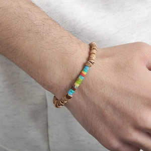 Detail of beaded bracelet with natural wood textures and multi-color stone beads on wrist