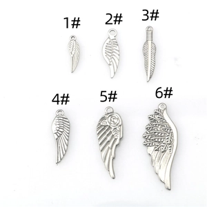 Detail view of six stainless steel feather charms with textured metallic wing designs
