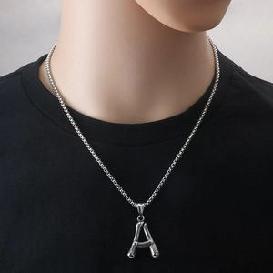 Collana in acciaio argento con pendente lettera A trama bambù su maglietta nera