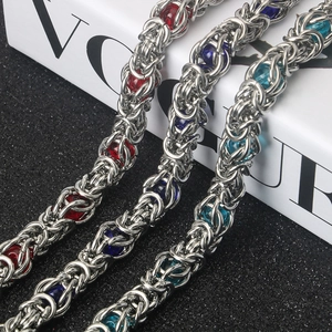 Macro shot of stainless steel byzantine chain bracelet with red and blue beads