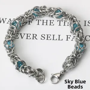 Detail of stainless steel braided bracelet with sky blue beads and lobster clasp