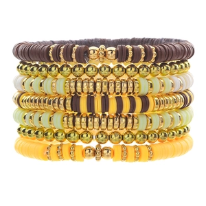 Detail of 7-piece bohemian stackable bracelets with heishi beads and gold metallic accents