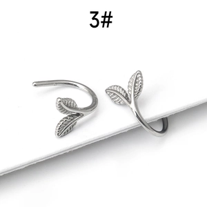 Macro detail of silver leaf earrings showing intricate vein textures and sleek metal finish