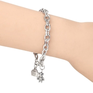 Minimalist stainless steel chain bracelet with bear and medical bag charms on wrist