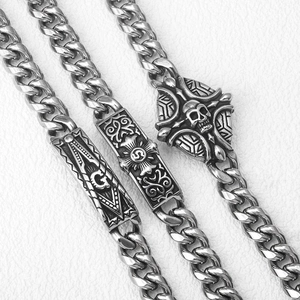 Detail of silver stainless steel curb bracelets with skull and Freemasonry charms