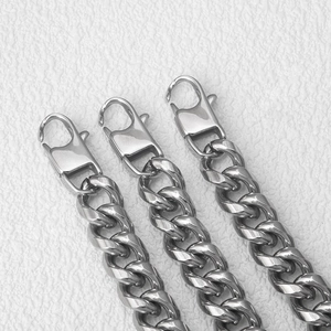 Close-up of triple stainless steel Cuban link chains with heavy lobster clasps for men