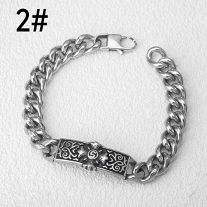 Macro detail of silver stainless steel chain bracelet with floral engraved S logo plate