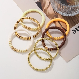 Close-up of bohemian 7-piece set with cream and orange clay discs and gold beaded bracelets