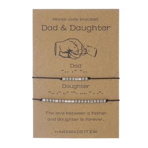 Detail of Morse code dad and daughter cord bracelets on gift card packaging