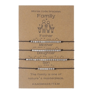 Detail of 4-piece family Morse code bracelet set with silver beads on kraft display card