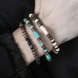Detailopname van een driedelige herenset met bruine houten kralen en turquoise armbanden