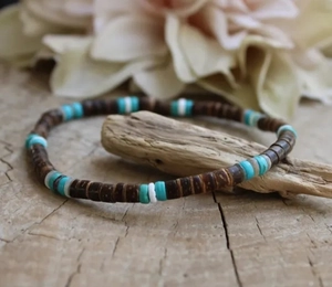 Macro-opname van bohemian armband met turquoise en kokosnootkralen op rustiek hout