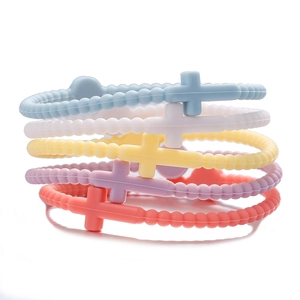 Close-up of five silicone macaron cross bracelets in pastel colors for kids and adults