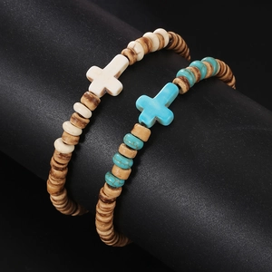 Detalle de cuentas de madera y colgantes de cruz turquesa en pulseras elásticas