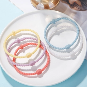 Close-up of pastel silicone beaded bracelets with cross charms in multiple colors