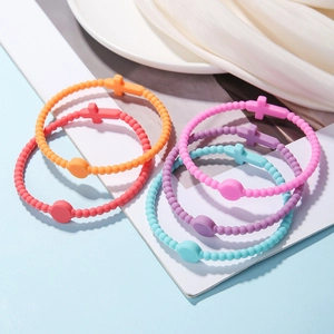 Macro detail of colorful silicone cross bead bracelets in orange, red, pink, purple and blue