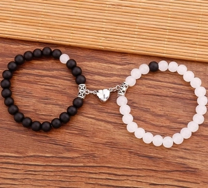 Dettaglio di bracciali magnetici per coppia con perline in pietra bianche e nere