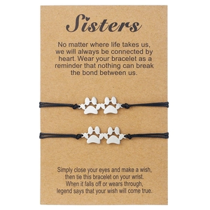 Détail de deux bracelets en cordon noir avec breloques de pattes argentées sur carte