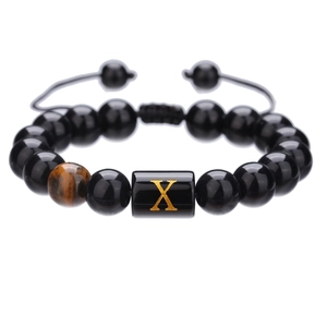 Detalle de pulsera de cuentas de ónix de 10mm con letra X dorada y cordón trenzado ajustable