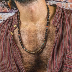 Collier rétro pour hommes avec perles en bois et turquoise sur fond de mur en briques
