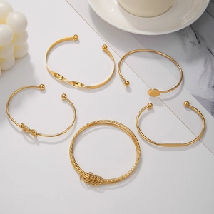 Set di 5 bracciali rigidi boho dorati impilabili con nodi e motivi geometrici