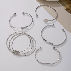 Dettaglio del set di 5 bracciali rigidi boho in metallo argento impilabili da donna