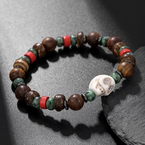 Gros plan du bracelet tête de mort avec perles turquoise, bois et détails ethniques