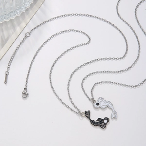 Matching Yin Yang koi fish pendants in black and white on stainless steel necklaces