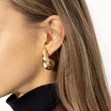 Close-up of elegant gold plated long teardrop earrings with luxury polished finish