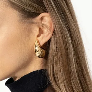 Nahaufnahme eleganter vergoldeter Tropfenohrringe mit luxuriösem Hochglanz-Finish