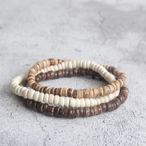Detail van boheemse gelaagde armbanden met natuurlijke houten en kokosnoot kralen textuur