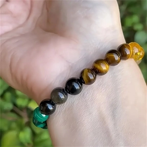 Bracciale artigianale con occhio di tigre, ossidiana e malachite sul polso