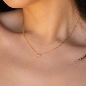 Vue détaillée d'un collier en or avec un pendentif solitaire en zircone de coupe ronde