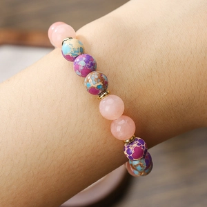 Nahaufnahme des handgefertigten Perlenarmbands mit rosa Quarz und bunten Steinen sowie Goldperlen